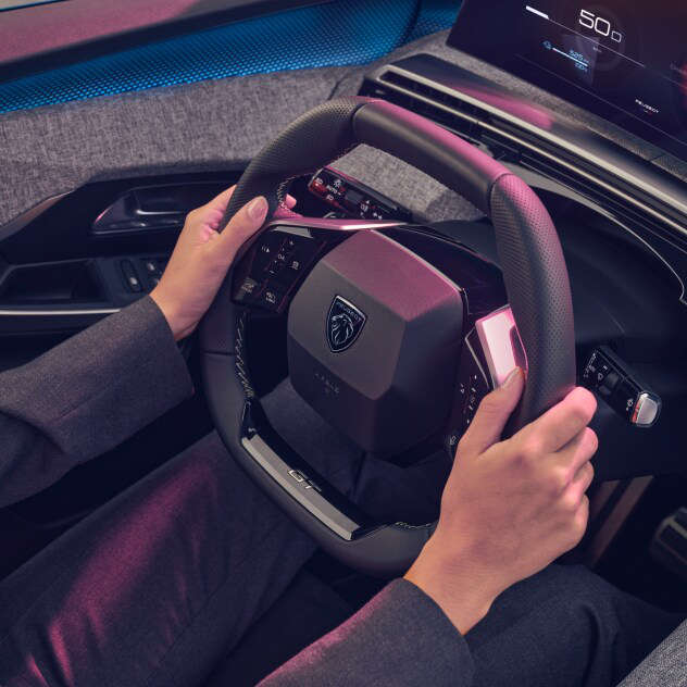 Руки на кермі у салоні Peugeot e-3008