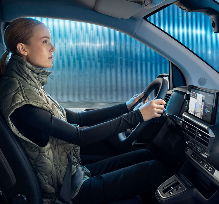 Молода жінка за кермом фургона Peugeot Expert