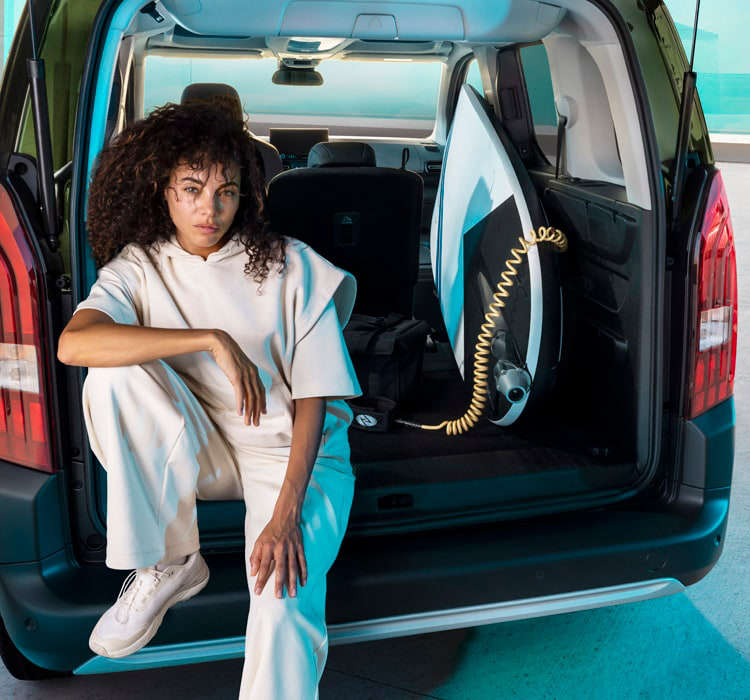 Жінка сидить у багажнику Peugeot e-Rifter